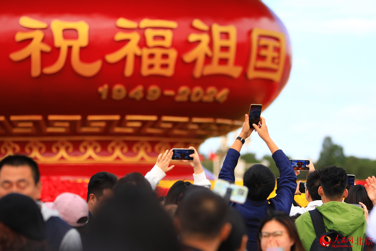 天安门广场“祝福祖国”花坛吸引游人参观拍照。人民网记者 尹星云摄