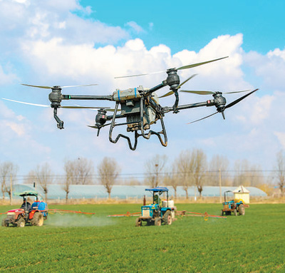  3月16日，山东青岛莱西市沽河街道，植保无人机、长臂喷雾机在田间对小麦进行管护。张进刚摄（人民视觉）