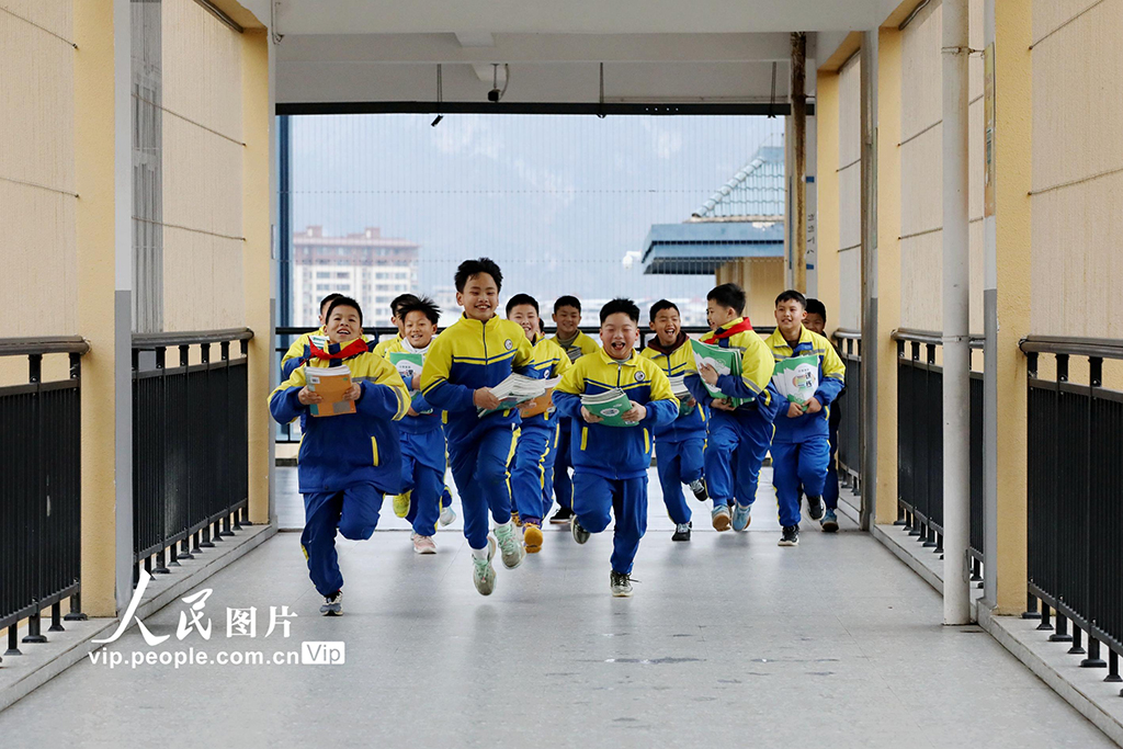 2026年3月2日,在贵州黔东南苗族侗族自治州施秉县第四小学,学生领到新课本后开心地奔跑。邰胜智摄(人民图片网)