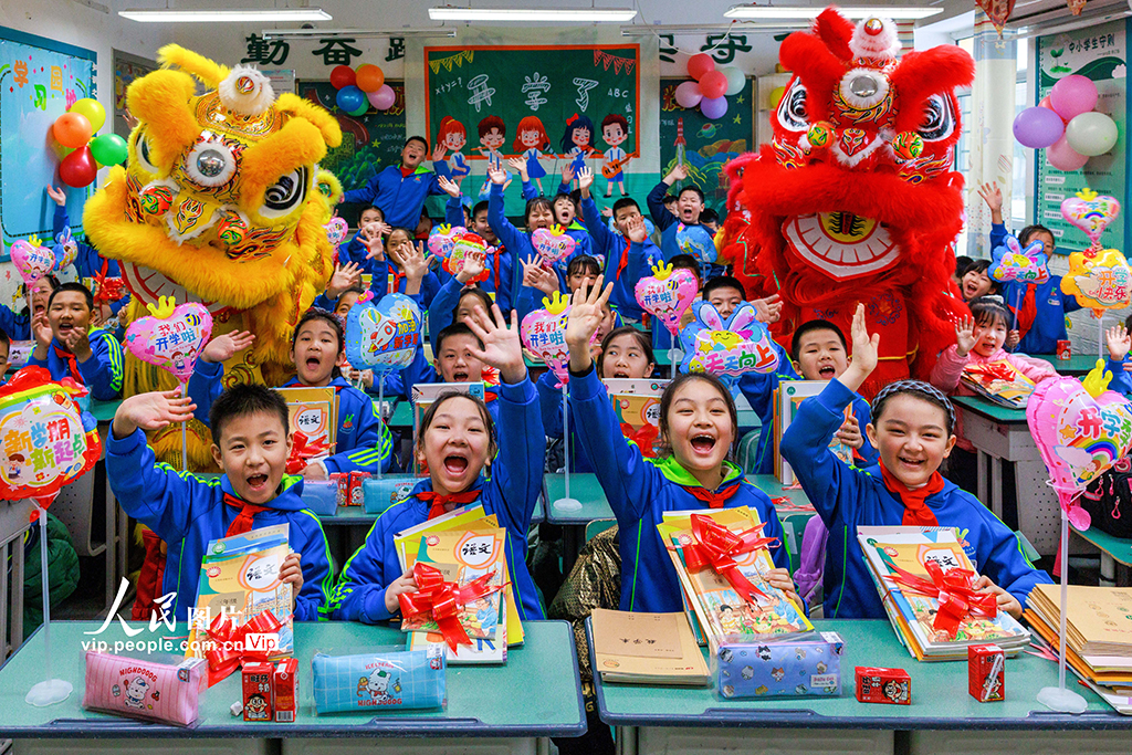 2026年3月1日,新疆乌鲁木齐市第二小学,学生们开心地展示着领到的新书。孙振嵩摄(人民图片网)