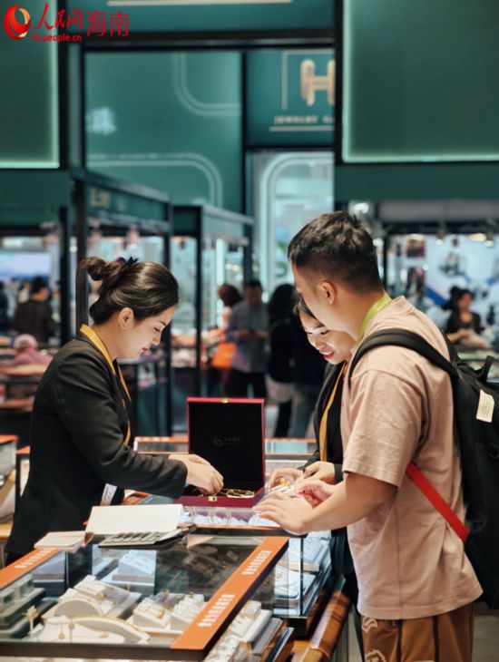 第五届消博会珠宝展区，工作人员向观众展示珠宝。人民网 符泽民摄