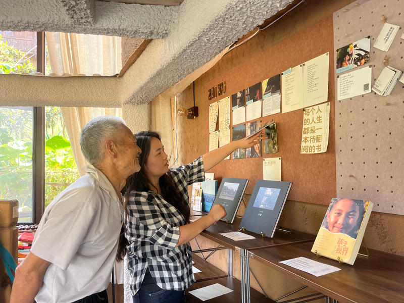 工作室负责人向村里老人介绍自己的作品。鿎石街道供图